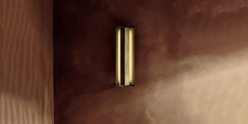AVA modern wall lights in aged brass on brown wall by KAIA
